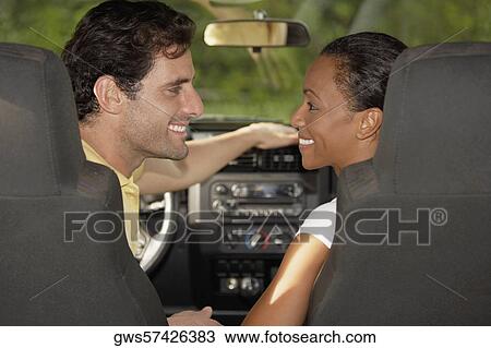 Close-up of a mid adult man and a young woman looking at each other in a jeep View Large Photo Image Stock Image - Close-up of a mid adult man and a young woman looking at each other in a jeep. Fotosearch