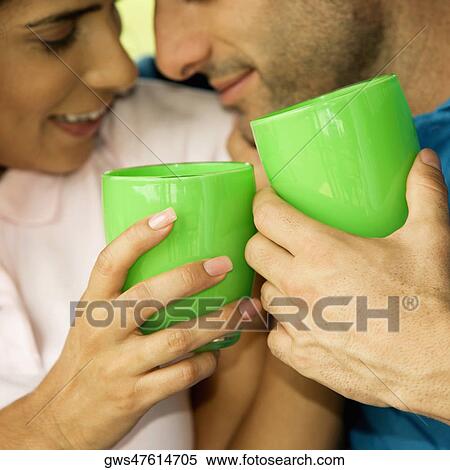 Stock Photography - Close-up of a mid adult man and a young woman holding glasses. Fotosearch