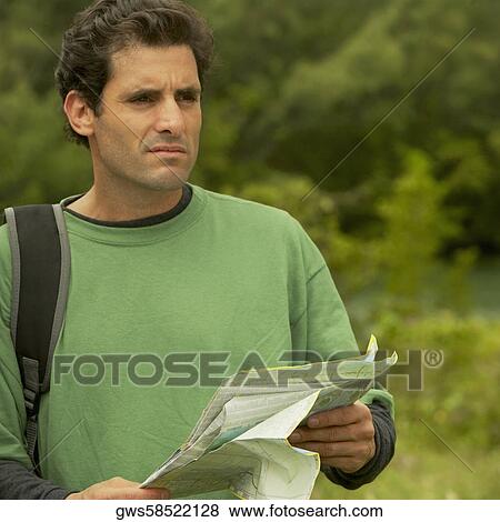 Close-up of a mid adult man holding a map View Large Photo Image Stock Photo - Close-up of a mid adult man holding a map. Fotosearch