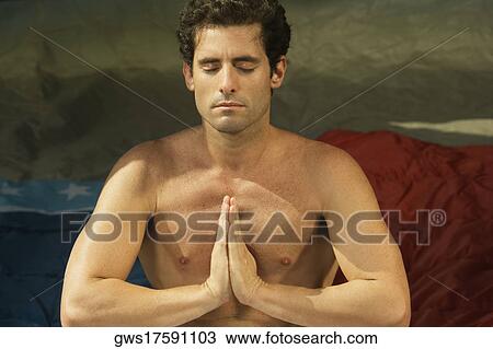Stock Image - Close-up of a mid adult man in a prayer position. Fotosearch