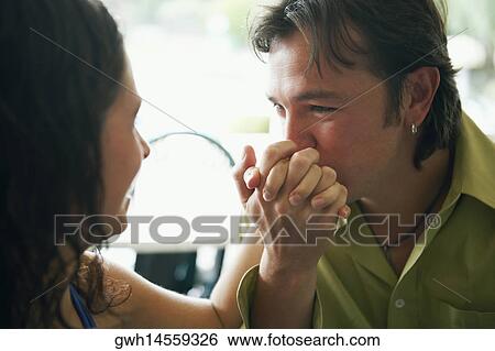 Stock Photograph - Close-up of a mid adult man kissing a young woman's hand. Fotosearch