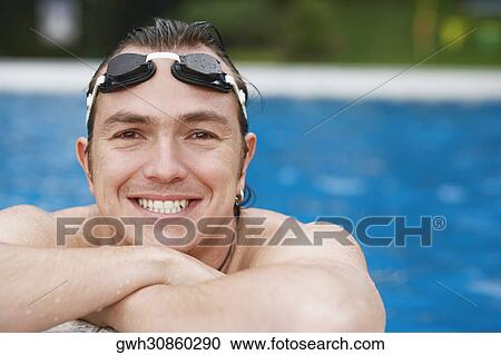 Stock Image - Close-up of a mid adult man leaning at the edge of a swimming pool. Fotosearch