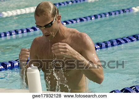 Stock Photo - Close-up of a mid adult man standing in a swimming pool. Fotosearch