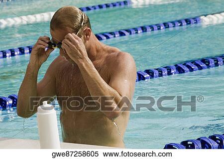 Stock Photography - Close-up of a mid adult man standing in a swimming pool. Fotosearch
