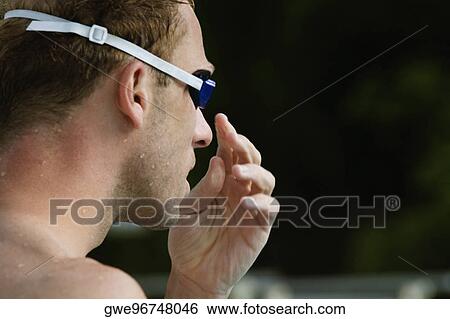 Stock Photograph - Close-up of a mid adult man wearing swimming goggles. Fotosearch