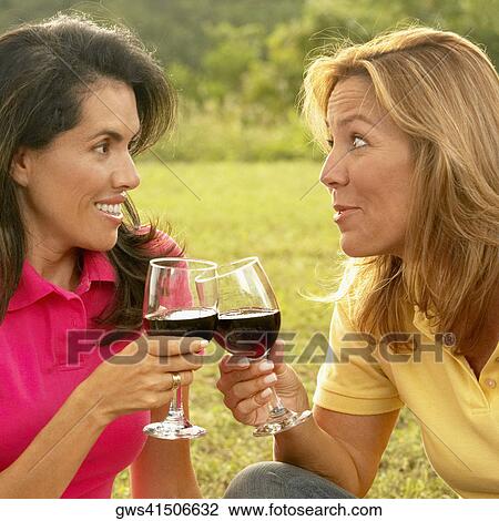 Close-up of a mid adult woman and a mature woman holding glasses of wine View Large Photo Image Stock Image - Close-up of a mid adult woman and a mature woman holding glasses of wine. Fotosearch