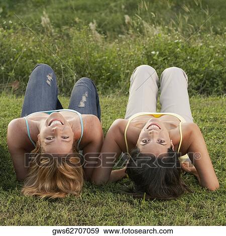 Stock Photo - Close-up of a mid adult woman and a mature woman lying on the grass. Fotosearch