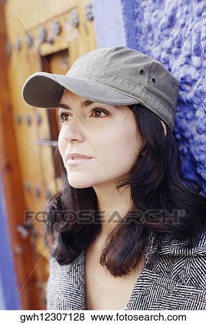 Close-up of a mid adult woman leaning against a wall  View Large Photo Image Stock Photo - Close-up of a mid adult woman leaning against a wall . Fotosearch