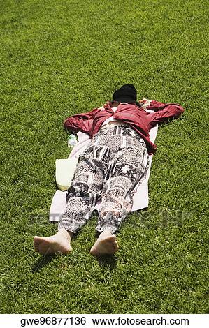 Stock Photograph - Close-up of a person resting in a lawn. Fotosearch
