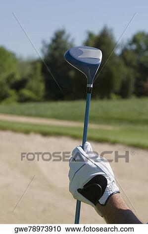 Stock Image - Close-up of a person's hand holding a golf club. Fotosearch