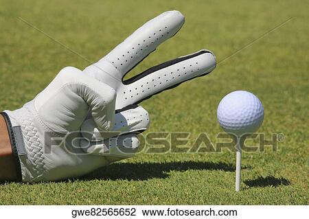 Close-up of a person's hand showing two fingers next to a golf ball on a tee View Large Photo Image Stock Image - Close-up of a person's hand showing two fingers next to a golf ball on a tee. Fotosearch