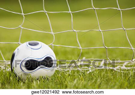 Stock Image - Close-up of a soccer ball near the net. Fotosearch