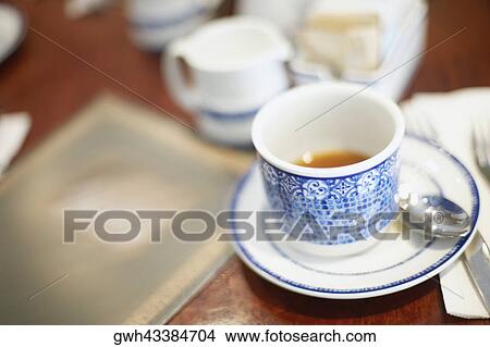 Close-up of a tea cup and a saucer on the table View Large Photo Image Picture - Close-up of a tea cup and a saucer on the table. Fotosearch