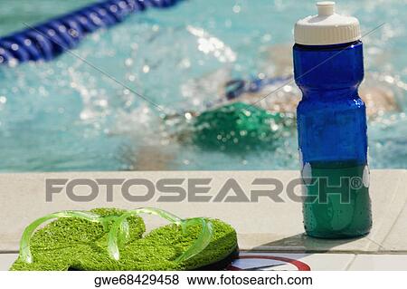 Close-up of a water bottle and a pair of flip-flops at the edge of a swimming pool View Large Photo Image Stock Photo - Close-up of a water bottle and a pair of flip-flops at the edge of a swimming pool. Fotosearch