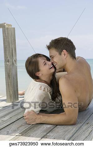 Close-up of a young couple lying on a pier and looking at each other View Large Photo Image Stock Image - Close-up of a young couple lying on a pier and looking at each other. Fotosearch