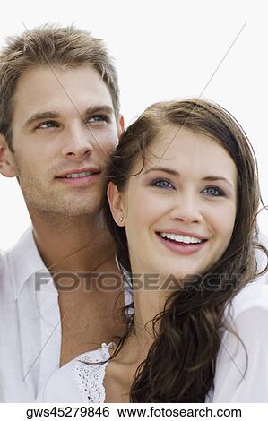 Close-up of a young couple smiling View Large Photo Image Stock Photograph - Close-up of a young couple smiling. Fotosearch