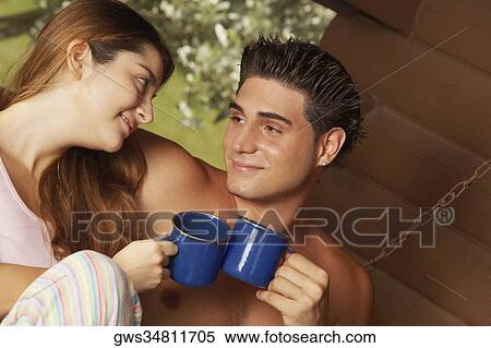 Stock Photography - Close-up of a young couple toasting cups of tea. Fotosearch