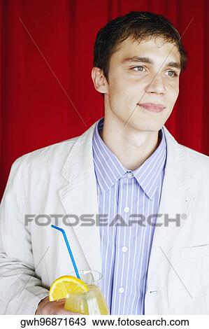 Close-up of a young man holding a drink View Large Photo Image Stock Image - Close-up of a young man holding a drink. Fotosearch
