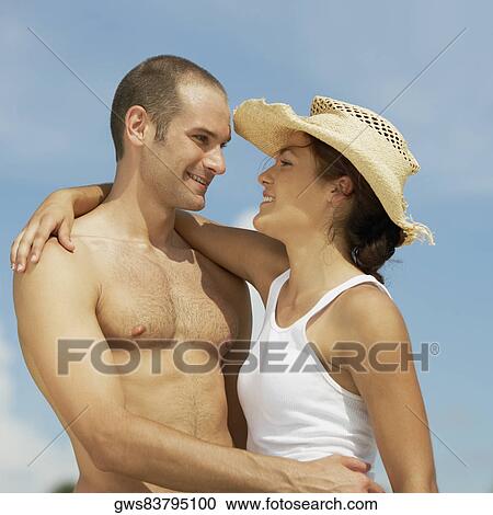 Stock Image - Close-up of a young man hugging a teenage girl. Fotosearch