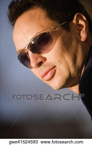 Close-up of a young man wearing sunglasses View Large Photo Image Stock Image - Close-up of a young man wearing sunglasses. Fotosearch