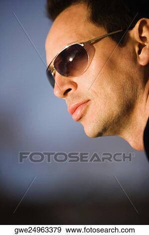 Close-up of a young man wearing sunglasses View Large Photo Image Stock Photo - Close-up of a young man wearing sunglasses. Fotosearch