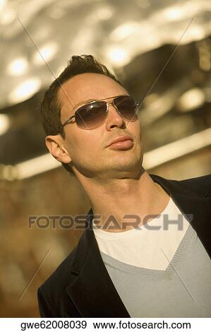 Close-up of a young man wearing sunglasses View Large Photo Image Stock Photo - Close-up of a young man wearing sunglasses. Fotosearch