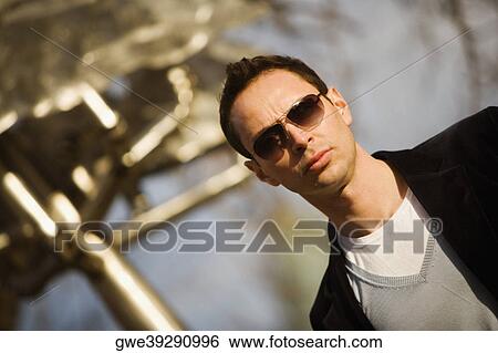 Stock Photograph - Close-up of a young man wearing sunglasses. Fotosearch
