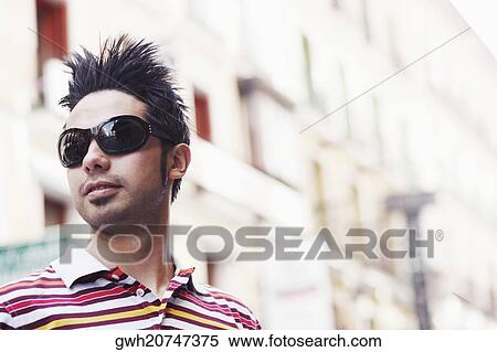 Close-up of a young man wearing sunglasses View Large Photo Image Stock Photography - Close-up of a young man wearing sunglasses . Fotosearch