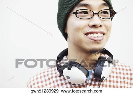 Stock Photo - Close-up of a young man with headphones around his neck. Fotosearch
