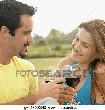Stock Image - Close-up of a young woman and a mature man toasting with wineglasses. Fotosearch