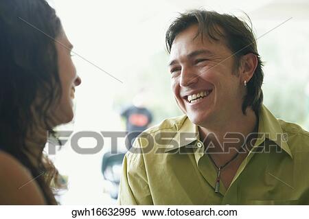 Close-up of a young woman and a mid adult man looking at each other and smiling in a restaurant View Large Photo Image Stock Photography - Close-up of a young woman and a mid adult man looking at each other and smiling in a restaurant. Fotosearch