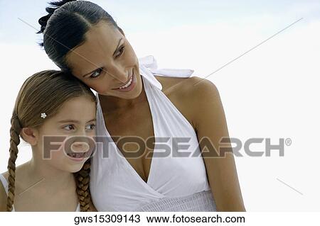 Close-up of a young woman and her daughter looking away View Large Photo Image Stock Image - Close-up of a young woman and her daughter looking away. Fotosearch