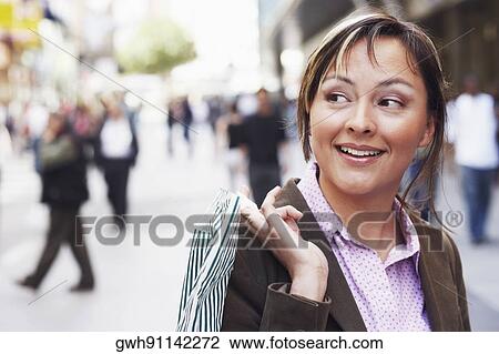 Close-up of a young woman holding a shopping bag View Large Photo Image Stock Image - Close-up of a young woman holding a shopping bag . Fotosearch