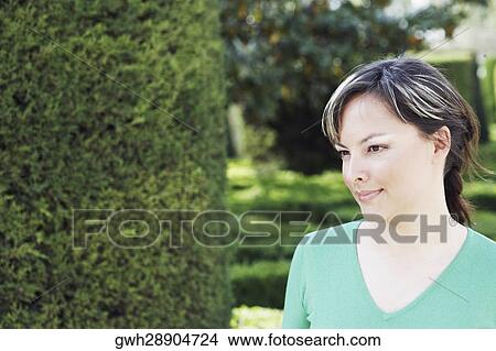 Close-up of a young woman looking away View Large Photo Image Picture - Close-up of a young woman looking away . Fotosearch