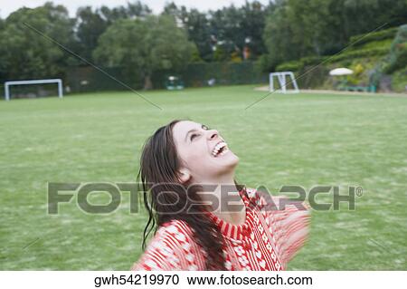 Stock Image - Close-up of a young woman looking up in a playing field. Fotosearch