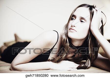 Close-up of a young woman lying on the bed View Large Photo Image Stock Image - Close-up of a young woman lying on the bed. Fotosearch