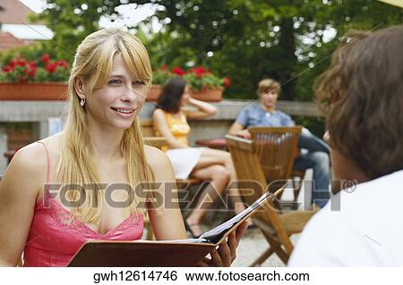 Stock Photograph - Close-up of a young woman sitting in front of a man . Fotosearch