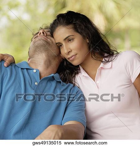 Close-up of a young woman sitting beside a sleeping mid adult man View Large Photo Image Stock Photography - Close-up of a young woman sitting beside a sleeping mid adult man. Fotosearch