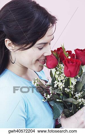 Close-up of a young woman smelling a bunch of roses View Large Photo Image Picture - Close-up of a young woman smelling a bunch of roses. Fotosearch