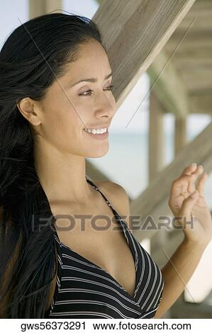 Close-up of a young woman smiling and looking away View Large Photo Image Stock Image - Close-up of a young woman smiling and looking away. Fotosearch