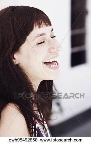 Close-up of a young woman smiling with her eyes closed View Large Photo Image Stock Photo - Close-up of a young woman smiling with her eyes closed. Fotosearch