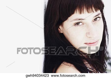 Close-up of a young woman smirking View Large Photo Image Stock Image - Close-up of a young woman smirking. Fotosearch