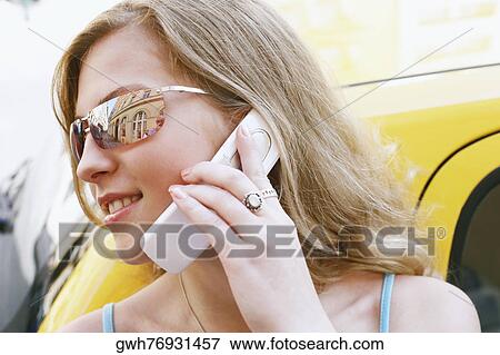 Close-up of a young woman talking on a mobile phone View Large Photo Image Stock Photo - Close-up of a young woman talking on a mobile phone . Fotosearch
