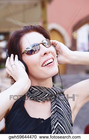 Close-up of a young woman wearing headphones View Large Photo Image Stock Image - Close-up of a young woman wearing headphones . Fotosearch