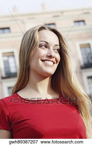 Stock Photo - Close-up of a young woman with her hands behind head . Fotosearch