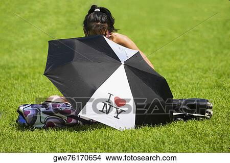 Close-up of an umbrella with a girl sitting behind it View Large Photo Image Picture - Close-up of an umbrella with a girl sitting behind it. Fotosearch