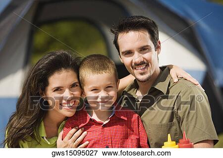 Close-up of parents smiling with their son View Large Photo Image Stock Photo - Close-up of parents smiling with their son. Fotosearch