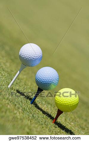 Close-up of three golf balls on three tees on a golf course View Large Photo Image Stock Image - Close-up of three golf balls on three tees on a golf course. Fotosearch