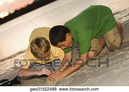 Close-up of two boys making a sand castle View Large Photo Image Stock Photo - Close-up of two boys making a sand castle. Fotosearch