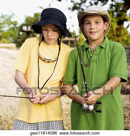 Close-up of two boys standing and holding fishing rods View Large Photo Image Stock Photograph - Close-up of two boys standing and holding fishing rods. Fotosearch